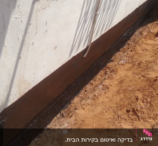 קיר עם איטום חום ליד אדמה חשופה